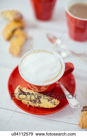 Stock Photo - Cups of latte and chocolate cantucci biscuits. Fotosearch