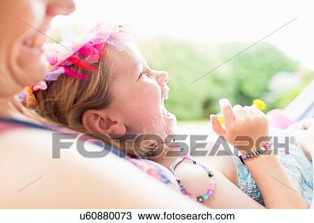 Stock Image - "Daughter lying on mother's lap, laughing". Fotosearch