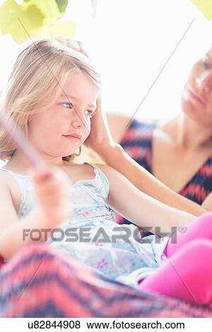 Daughter sitting on mother's lap View Large Photo Image Stock Photo - Daughter sitting on mother's lap. Fotosearch
