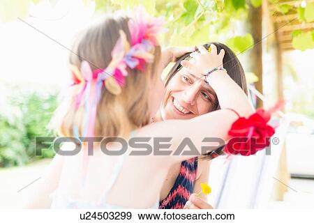 Stock Photo - Daughter styling mother's hair. Fotosearch