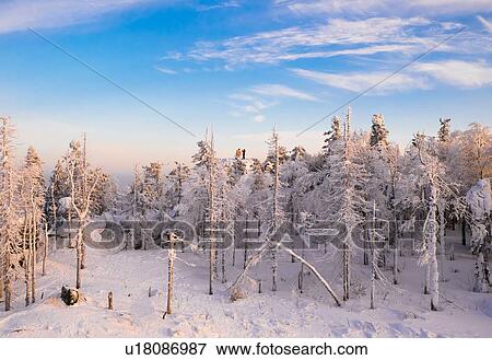 Stock Photo - "Distant view of mid adult couple looking out from snow covered rock, Nizhniy Tagil, Sverdlovsk Region, Russia". Fotosearch