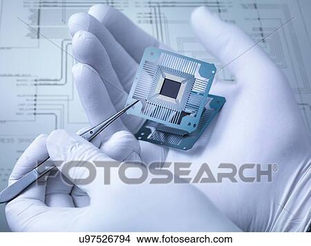 Picture - "Electronic components held in hand in laboratory, close up". Fotosearch