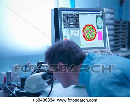 Electronics worker checking components in clean room laboratory View Large Photo Image Picture - Electronics worker checking components in clean room laboratory. Fotosearch