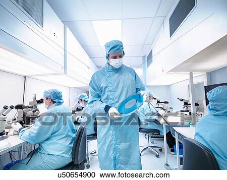 Electronics worker in clean room holding silicon wafer View Large Photo Image Stock Image - Electronics worker in clean room holding silicon wafer. Fotosearch