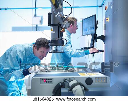 Stock Photography - Electronics workers checking components in clean room laboratory. Fotosearch