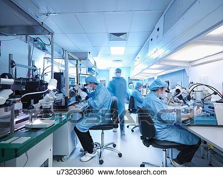 Stock Image - Electronics workers in clean room laboratory. Fotosearch