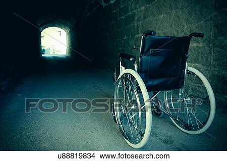 Empty wheelchair in dark tunnel View Large Photo Image Picture - Empty wheelchair in dark tunnel. Fotosearch