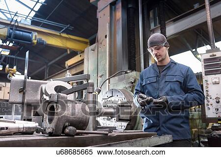 Engineer at lathe in engineering factory View Large Photo Image Stock Photography - Engineer at lathe in engineering factory. Fotosearch