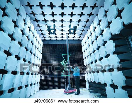 Stock Photo - Engineer checking a bilog antenna's height for electromagnetic compatibility (EMC) radiated immunity testing in a semi anechoic chamber. Fotosearch