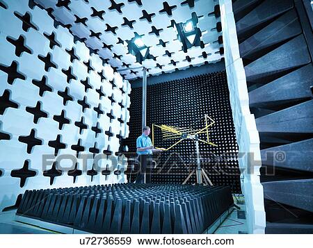 Stock Photo - Engineer checking the bilog antenna set up for electromagnetic compatibility (EMC) radiated emissions in anechoic chamber with energy absorbers. Fotosearch