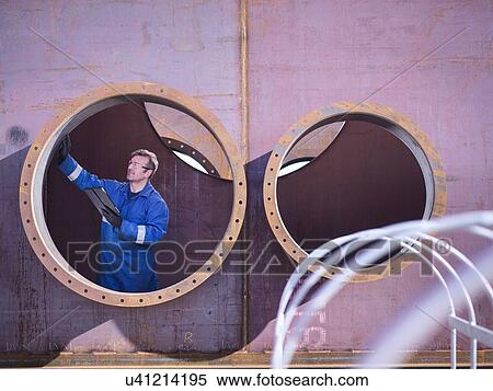 Engineer inspecting large steel superstructure in engineering factory View Large Photo Image Stock Photography - Engineer inspecting large steel superstructure in engineering factory. Fotosearch