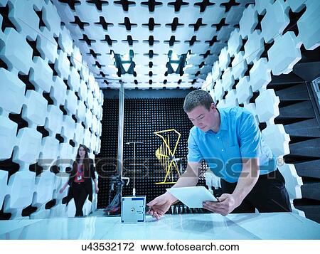 "Engineers checking equipment under test (EUT), a continous noise source in fully anechoic chamber with energy absorbers and bilog antenna" View Large Photo Image Stock Image - "Engineers checking equipment under test (EUT), a continous noise source in fully anechoic chamber with energy absorbers and bilog antenna". Fotosearch