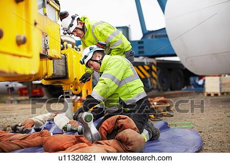Stock Image - Engineers preparing to work on wind turbine. Fotosearch