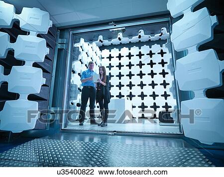 Stock Image - Engineers reviewing test results in laboratory in an anechoic chamber used for electromagnetic compatibility testing of electrical and electronic equipment. Fotosearch