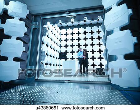 Stock Image - Engineers reviewing test results in laboratory in an anechoic chamber used for electromagnetic compatibility testing of electrical and electronic equipment. Fotosearch