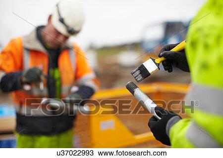 Stock Image - Engineers working at wind farm. Fotosearch