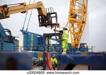 Stock Photo - Engineers working at wind farm. Fotosearch