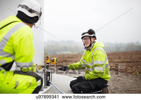 Stock Image - Engineers working on wind turbine. Fotosearch