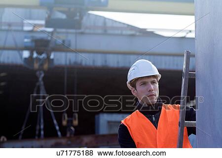 Factory worker on ladder checking concrete block in concrete reinforcement factory View Large Photo Image Stock Photo - Factory worker on ladder checking concrete block in concrete reinforcement factory. Fotosearch