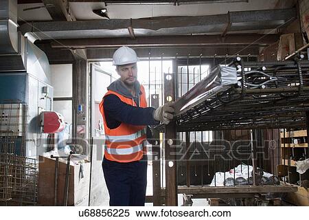 Stock Photography - Factory worker selecting steel mesh in concrete reinforcement factory. Fotosearch
