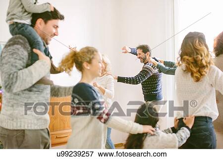 Stock Photo - Family doing the conga at family Christmas party. Fotosearch
