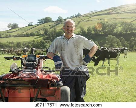 Farmer in field with cows and quadbike View Large Photo Image Stock Image - Farmer in field with cows and quadbike. Fotosearch