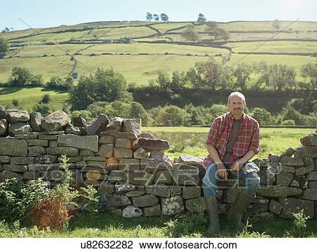 Farmer sitting by dry stone wall in field View Large Photo Image Stock Image - Farmer sitting by dry stone wall in field. Fotosearch