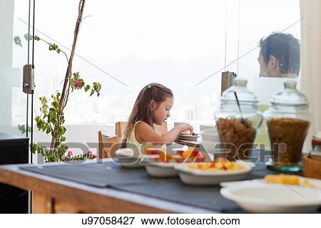 "Father and daughter sitting at breakfast table on balcony, healthy food in foregound" View Large Photo Image Stock Photo - "Father and daughter sitting at breakfast table on balcony, healthy food in foregound". Fotosearch