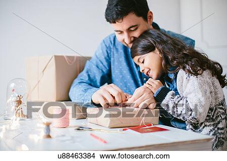Picture - Father and daughter wrapping Christmas gifts. Fotosearch