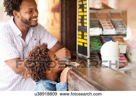 Stock Photo - "Father and son at beach bar on Ipanema beach, Rio De Janeiro, Brazil". Fotosearch