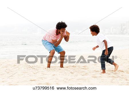 Stock Photograph - "Father and son playing on beach, RIo de Janeiro, Brazil". Fotosearch