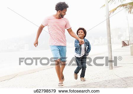 "Father and son running hand in hand at Ipanema beach, Rio De Janeiro, Brazil" View Large Photo Image Stock Photo - "Father and son running hand in hand at Ipanema beach, Rio De Janeiro, Brazil". Fotosearch