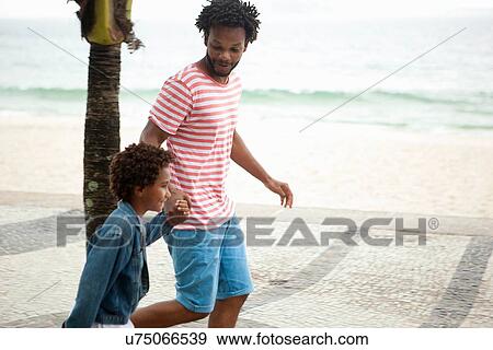 "Father and son running hand in hand on Ipanema beach, Rio De Janeiro, Brazil" View Large Photo Image Stock Photo - "Father and son running hand in hand on Ipanema beach, Rio De Janeiro, Brazil". Fotosearch
