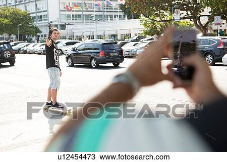 "Father taking smartphone photograph of son skateboarding, Copacabana, Rio De Janeiro, Brazil" View Large Photo Image Stock Image - "Father taking smartphone photograph of son skateboarding, Copacabana, Rio De Janeiro, Brazil". Fotosearch
