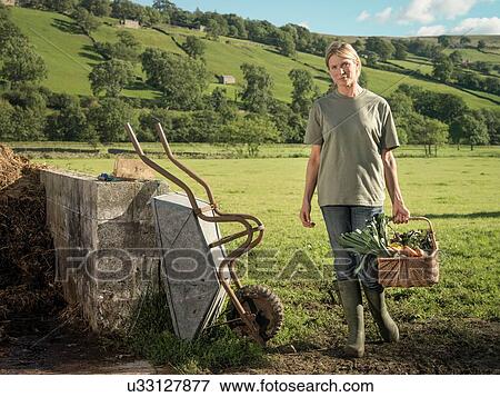 "Female farmer holding basket of organic vegetables, portrait" View Large Photo Image Stock Photo - "Female farmer holding basket of organic vegetables, portrait". Fotosearch
