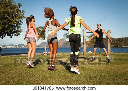 Stock Photography - "Female friends exercising in park with personal trainer, Rio De Janeiro, Brazil". Fotosearch