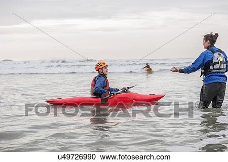 Female instructor helping young man in sea kayak View Large Photo Image Stock Image - Female instructor helping young man in sea kayak. Fotosearch