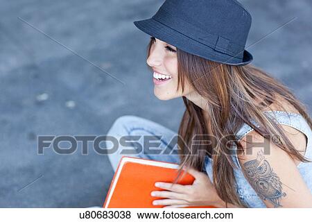 Female student wearing hat holding book View Large Photo Image Stock Photo - Female student wearing hat holding book. Fotosearch