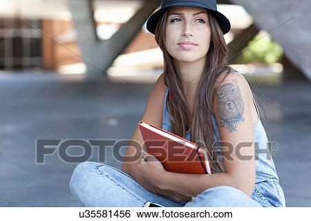 Female student with tattoo holding book View Large Photo Image Stock Photograph - Female student with tattoo holding book. Fotosearch