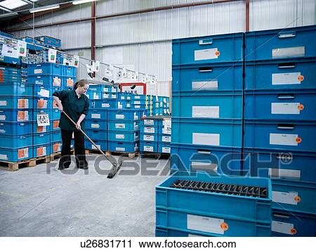 Female worker sweeping amongst stacked blue crates in factory View Large Photo Image Stock Image - Female worker sweeping amongst stacked blue crates in factory. Fotosearch