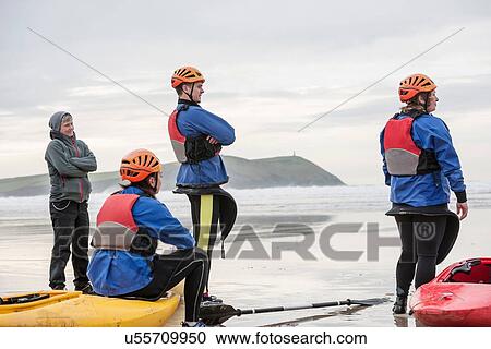 "Four people on beach with kayaks, Polzeath, Cornwall, England" View Large Photo Image Stock Image - "Four people on beach with kayaks, Polzeath, Cornwall, England". Fotosearch