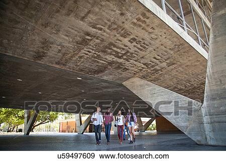 Four students walking underneath building View Large Photo Image Stock Photo - Four students walking underneath building. Fotosearch