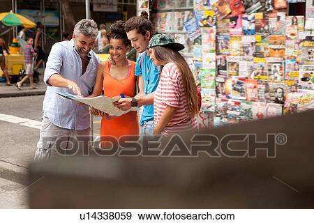Stock Photo - "Four tourist friends reading map, Copacabana town, Rio De Janeiro, Brazil". Fotosearch