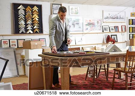 Framer arranging objects in picture in picture framers workshop View Large Photo Image Stock Photo - Framer arranging objects in picture in picture framers workshop. Fotosearch