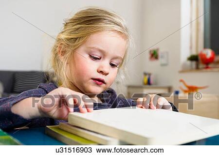 Stock Image - Girl arranging square blocks on table. Fotosearch