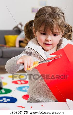 Girl cutting coloured card at home View Large Photo Image Stock Photography - Girl cutting coloured card at home. Fotosearch