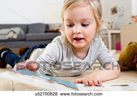 Stock Photo - Girl lying on floor at home. Fotosearch