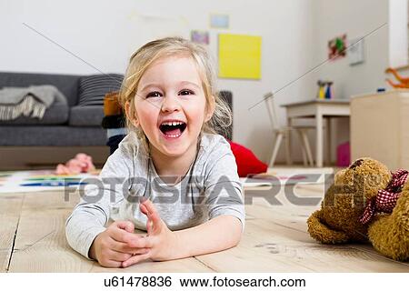 Girl lying on floor at home View Large Photo Image Stock Photograph - Girl lying on floor at home. Fotosearch