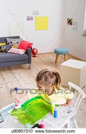 Stock Image - Girl painting on paper at home. Fotosearch
