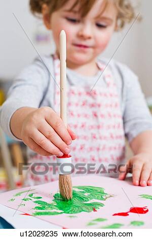 Stock Photography - Girl painting on paper at home. Fotosearch